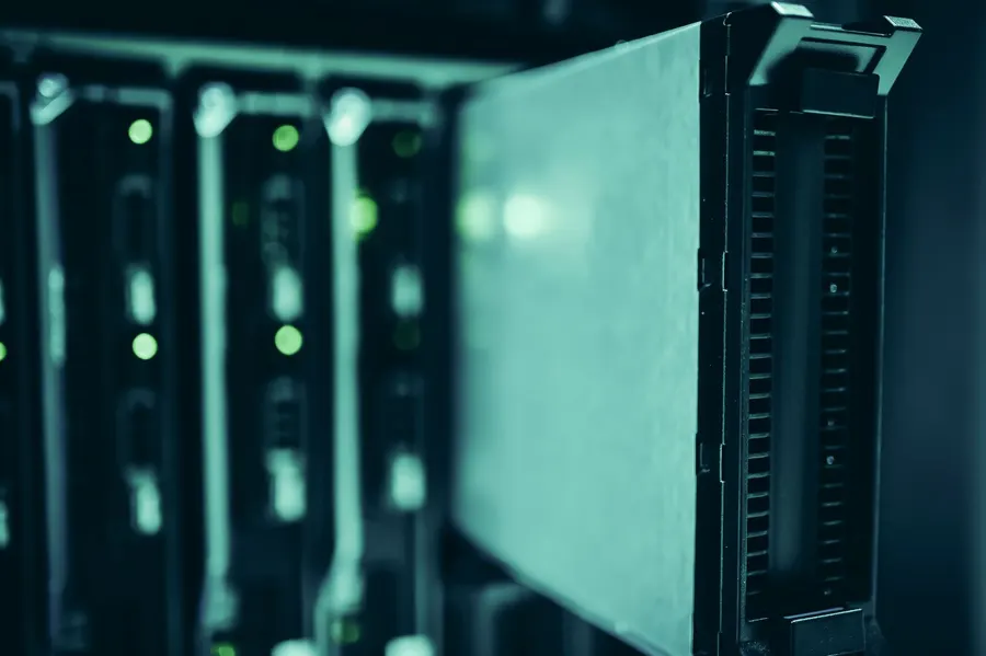 Nahaufnahme eines Servers im Gestell mit grün leuchtenden Statusanzeigen